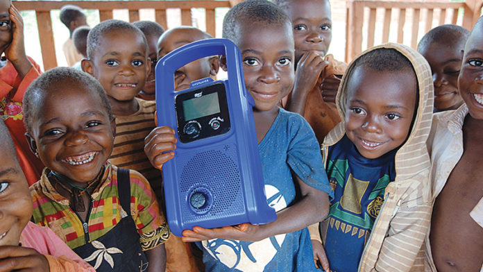 photo3_handcrank_tworabbits_contributed_JanAAF20_150 Children in Cameroon hold a crank-powered mp3 player used to deliver preschool lessons to them through the Two Rabbits nonprofit organization. Ann Arbor native Sarah Strader started the organization to help the Baka children of Cameroon find success in a formal classroom setting and their forest home. Photo contributed by Sarah Strader
